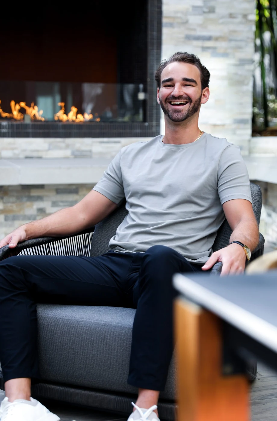 Joshua laughing in conversation beside a fireplace